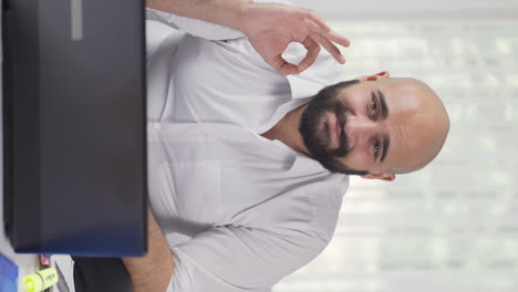 Vertical-video-of-Home-office-worker-man-making-positive-gesture-at-camera.